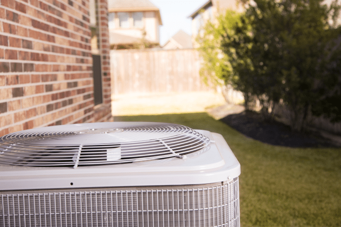 close up view of an outdoor air conditioning unit on the side of a house