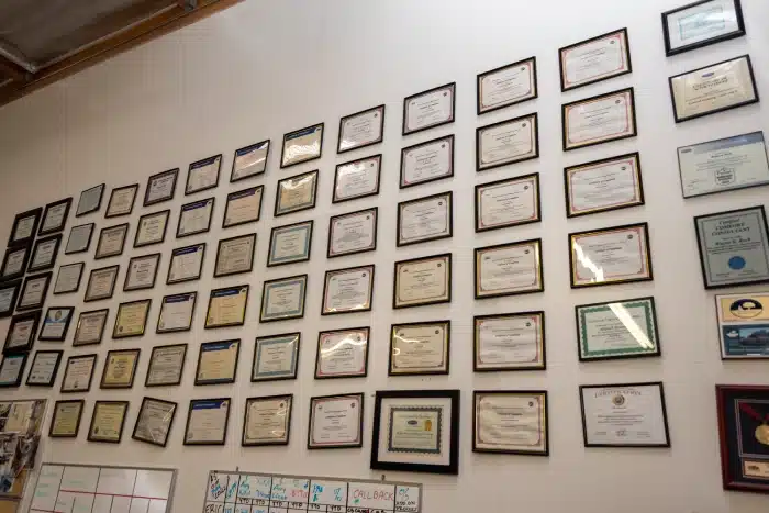 Huge collection of awards for Aladdin AC hanging on a white wall