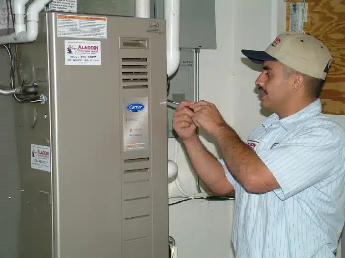 Technician working on a Carrier HVAC unit inside a home