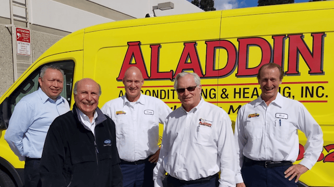 Team of Aladdin HVAC owners in front of company branded truck in the background.