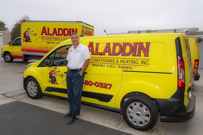 Why Buying a Heat Pump Instead of a Furnace Makes Sense. Photo of a technician standing in front of an Aladdin Heating van.