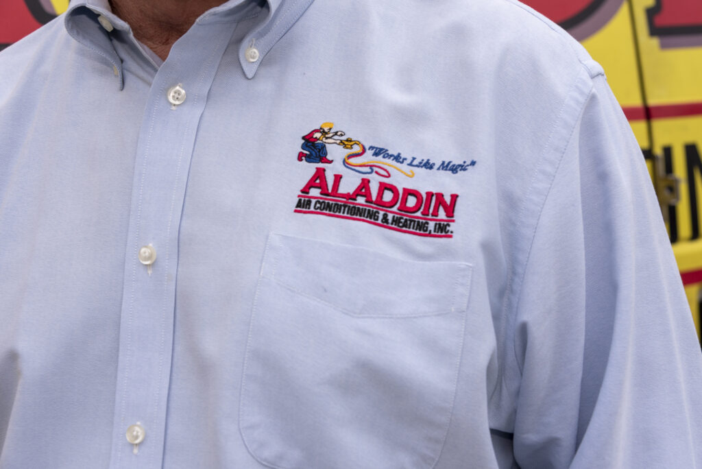 Aladdin HVAC logo on technician's work shirt.