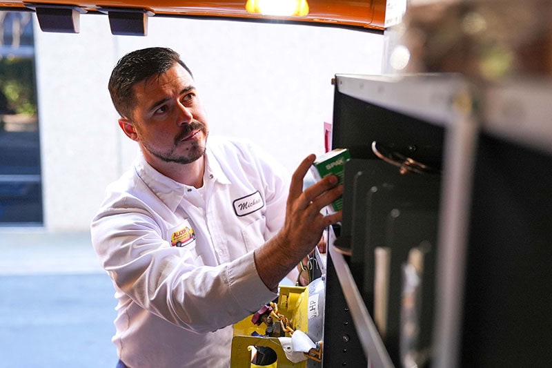 HVAC technician performing maintenance on a system.